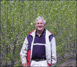 Fred Ruguske next to hybrid trees on CRP land
