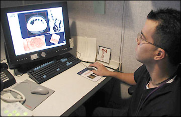 Troy Mansell looks at CT scan on computer