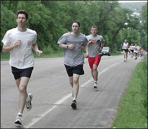 runners scale a hill near lake koronis