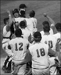 Sophomore Adam Kampsen gets mobbed as he scores the winning run on a balk.